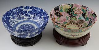 Two Chinese Porcelain Serving Bowls, 19th c., one Famille Rose, with a scalloped rim, the second with blue and white decoration, both on carved wooden