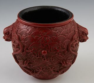 Chinese Cinnabar Baluster Vase, 20th c., with dragon head handles on relief dragon carved sides, H.- 5 1/4 in., W.- 7 in., D.- 5 1/2 in. Provenance: f