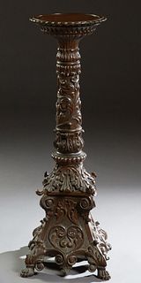 American Highly Carved Mahogany Pedestal, early 20th c., the dished circular top over a tapered relief carved cylindrical support, to a leaf carved sl