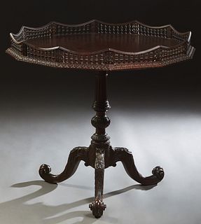 English Carved Mahogany Galleried Lamp Table, 19th c., of dodecahedron form, the top with a shaped spindled gallery, on a reeded and turned support, t