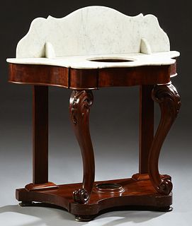 American Carved Mahogany Marble Top Washstand, 19th c., the arched figured white marble splash over a like marble top with a cutout for a bowl, on scr