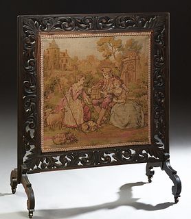 Ebonized Carved Wooden Fire Screen, c. 1890, with a pierced leaf form frame with a central needlepoint panel of lovers in a garden holding a birdcage,