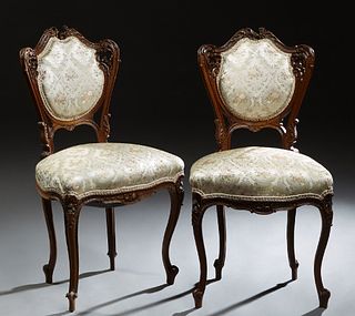 Pair of French Louis XV Style Carved Mahogany Parlor Chairs, 19th c., the arched serpentine crest rail over an upholstered cushioned medallion back, t