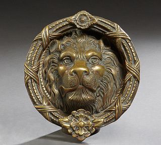 Large Bronze Lion Head Door Knocker, late 19th c., the knocking ring with relief floral decoration over a high relief lion's head, H.- 9 in., W.- 8 1/