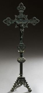 Bronze Table Crucifix, early 20th c., with pierced floral decoration on a knopped support, to a tripodal base with scroll decorated legs, H.- 24 1/2 i