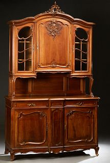 French Provincial Louis XV Style Carved Walnut Buffet a Deux Corps, 19th c., the arched leaf carved crest over an ogee crown and a central arched fiel