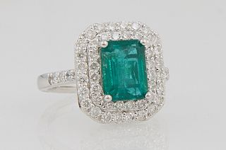 Lady's Platinum Dinner Ring, with a 2.37 carat emerald atop a double graduated concentric border of small round diamonds, the shoulders of the band al
