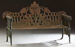 American Aesthetic Style Cast Iron Garden Bench, 20th c., the pierced back with relief leaf and branch decoration, flanked by relief arms with dog hea