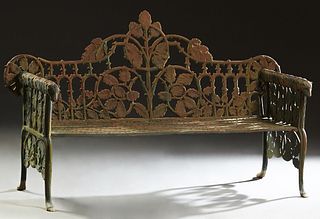 American Aesthetic Style Cast Iron Garden Bench, 20th c., the pierced back with relief leaf and branch decoration, flanked by relief arms with dog hea