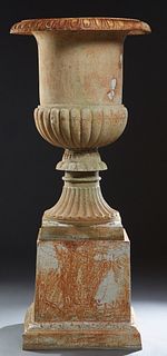 Monumental Cast Iron Campana Form Garden Urn, 21st c., the relief everted rim over a sloping reeded socle support to a square plinth on a pedestal bas