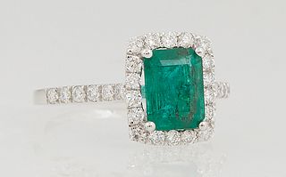 Lady's Platinum Dinner Ring, with a 1.44 ct. emerald atop a border of small round diamonds, the shoulders of the band also mounted with small round di