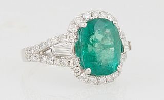 Lady's Platinum Dinner Ring, with a cushion cut 4.31 ct. emerald, atop a diamond mounted border, with diamond baguette mounted lugs within the split d