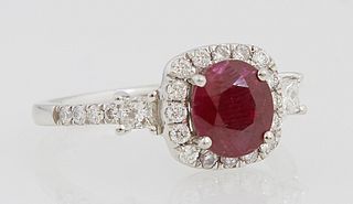 Lady's Platinum Dinner Ring, with a cushion cut 1.21 ct. ruby atop a conforming band of round diamonds, flanked by round diamond mounted lugs, the sho