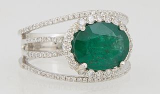 Lady's Platinum Dinner Ring, with a 3.36 ct. oval emerald atop a border of round diamonds, flanked by outer bands of tiny round diamonds, and a split 