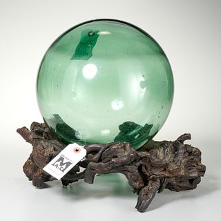 Green glass witch ball on tree-root stand