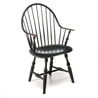 A CONTINUOUS ARM WINDSOR CHAIR IN OLD BLACK PAINT C 1800