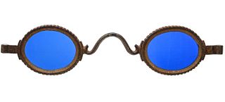 AN IRON OPTOMETRIST TRADE SIGN WITH ELECTRIC BLUE GLASS