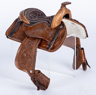 Two miniature tooled leather saddles