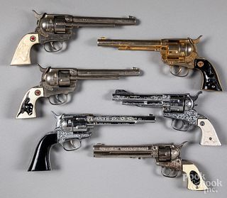 Six toy cap guns with rotating cylinders