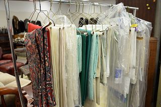 Rack of tablecloths and linens, some large.