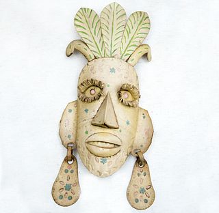 Máscara antropomorfa. México. Siglo XX. Elaborada en hojalata policromada. Decorada con pendientes y tocado vegetal.
