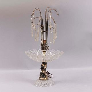Lámpara de mesa. Siglo XX. Elaborada en metal y cristal. Para una luz. Decorada con amorcillos y péndulos de cristal.