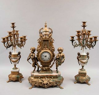 Guarnición. Italia. SXX. Marcado Imperial en cáratula. Elaborado en bronce y mármol. Consta de: reloj de chimenea y par de candelabros.