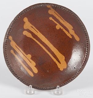 Pennsylvania slip decorated redware pie plate, 19th c., 7'' dia.