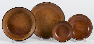 Four redware plates and shallow bowls, 19th c., ranging from 5'' - 9'' dia.