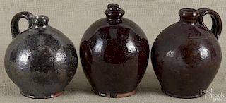 Three Pennsylvania redware jugs, 19th/20th c., largest - 6 1/2'' h.