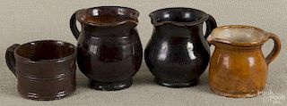 Three Pennsylvania small redware pitchers, 19th c., largest - 3 3/4'' h., together with a redware cup