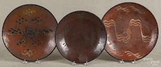 Three slip-decorated Pennsylvania redware pie plates, 19th c., largest - 10 1/2'' dia.