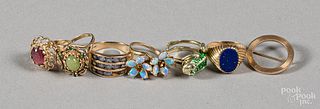 Six 14K gold and gemstone rings and a brooch.