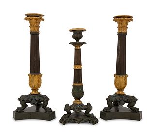 A Pair of Neoclassical Gilt Bronze Candlesticks and a Similar Candlestick