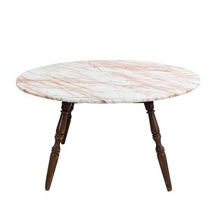 Mesa de centro. Siglo XX. En talla de madera. Con cubierta circular de mármol rosado jaspeado. 75 x 140 cm Ø