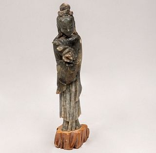 Guan Yin. Origen oriental. Siglo XX. Talla en serpentina con base de madera.                             24 x 6 x 3 cm.