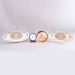 Lote de charolas y platos. Francia, siglo XX. Elaborados en porcelana Limoges. Consta de: plato con base, plato miniatura y otros.