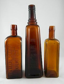 3 amber bitters bottles
