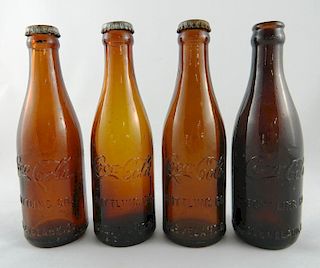 Four Coca Cola Amber bottles