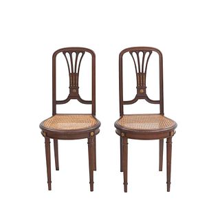 Lote de 2 sillas. Francia. Siglo XX. En talla de madera de roble. Con respaldos semiabiertos y asientos de bejuco.