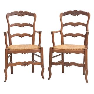 Par de sillones. Francia. Siglo XX. Estilo Luis XV. En talla de madera de roble. Con respaldos escalonados y asientos de palma.