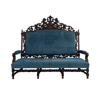 Sofá. Francia. Siglo XX. En talla de madera de nogal. Con respaldo cerrado y asiento en tapicería color azul.