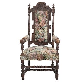 Sillón. Francia. Siglo XX. Estilo Enrique II. En talla de madera de roble. Con respaldo cerrado y asiento en tapicería floral.