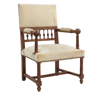 Sillón. Francia. Siglo XX. En talla de madera de nogal. Con respaldo semiabierto y asiento en tapicería color beige.