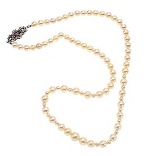 Collar con perlas, rubíen y plata paladio. 65 perlas cultivadas color crema de 6 a 8 mm. 3 rubíes. 16 imitantes de perla. Peso: 33.1 g