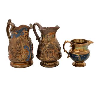 Lote de 3 piezas. Siglo XIX. Elaborados en cerámica con esmalte "Copper Luster". Consta de: cremera y 2 jarras.