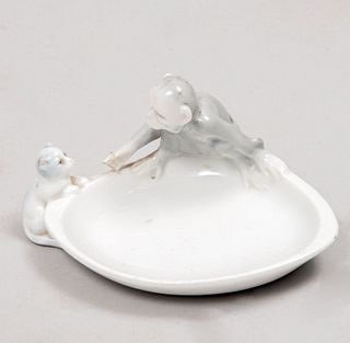 Depósito. Alemania. Principios del siglo XX. Elaborado en porcelana Metzler & Ortloff. Diseño oval. Decorado con mono y gato.