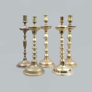 Lote de 5 candeleros. Siglo XX. Elaborados en metal dorado y lámina. Con arandelas circulares, fustes compuestos y soportes circualres.