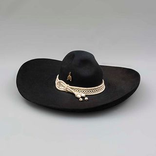 Sombrero de faena. SXX. Elaborado en fieltro color negro. Decorado con toquilla de cordón en hilo plateado y aplicaciones de espuelas.