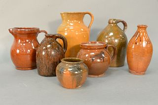 Group of Seven Redware Pieces to include two jugs with handles, one with mottled brown and black glaze; covered pot with slip decoration; two large pi